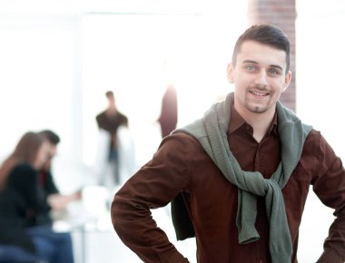 Kendine güvenen genç adam ofis arka planda.