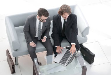 dizüstü bilgisayarda veri tartışırken iş arkadaşları.