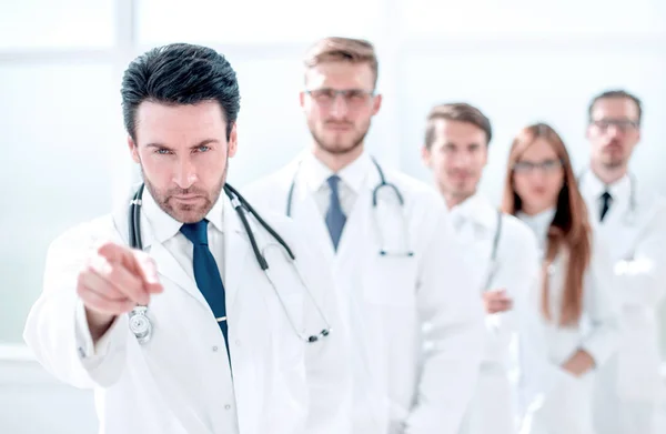 Medico rigoroso, indicando voi, in piedi sul posto di lavoro — Foto Stock