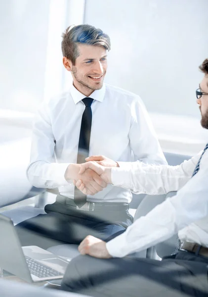 Succesvolle medewerkers schudden handen zitten aan de balie — Stockfoto