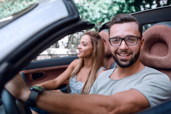 Close up.stylish homem com sua namorada viajando em um carro conversível . — Fotografia de Stock