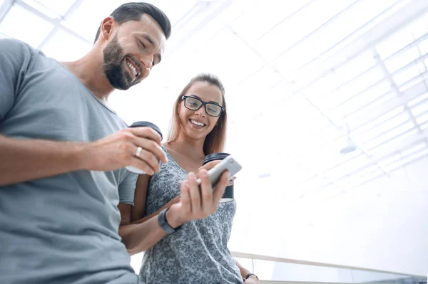 Pareja joven leyendo SMS en su teléfono inteligente — Foto de Stock