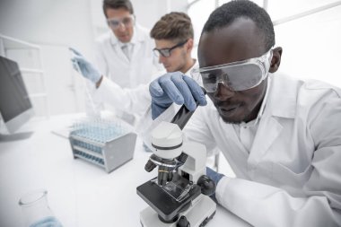 Modern bilim adamı bir laboratuarda mikroskop kullanır