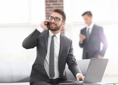 Ofiste kendine güveni tam genç bir adam konuşuyor.