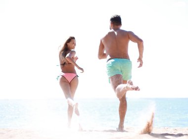 Kumsalda koşan bir çift.