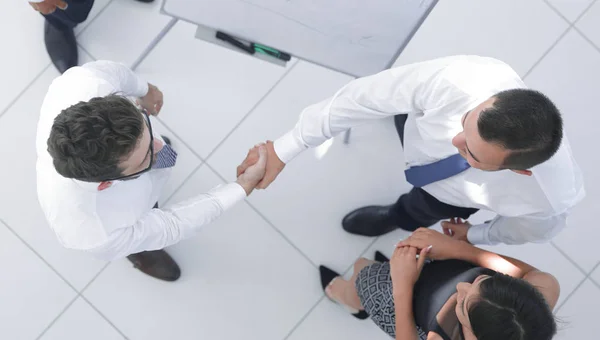 Blick von oben. Hintergrundbild des Handschlags von Geschäftspartnern — Stockfoto