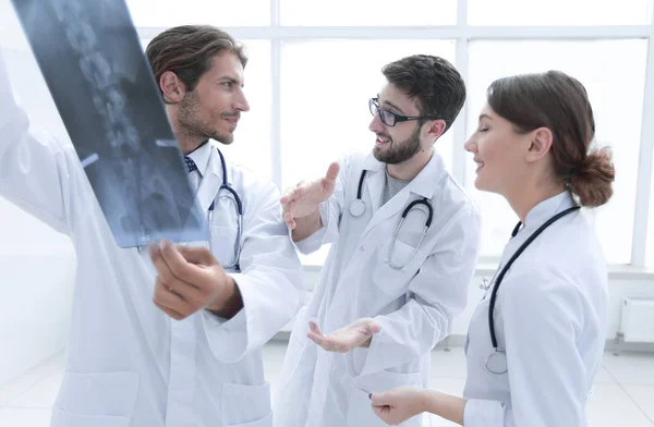 Три впевнені лікарі досліджують рентгенівський знімок — стокове фото