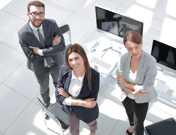 Ovanifrån. tre anställda stående på kontoret — Stockfoto