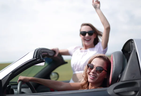 Close up. Dos mujeres jóvenes felices en un coche convertible — Foto de Stock
