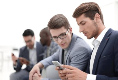 İş arkadaşları akıllı telefondan SMS okuyor