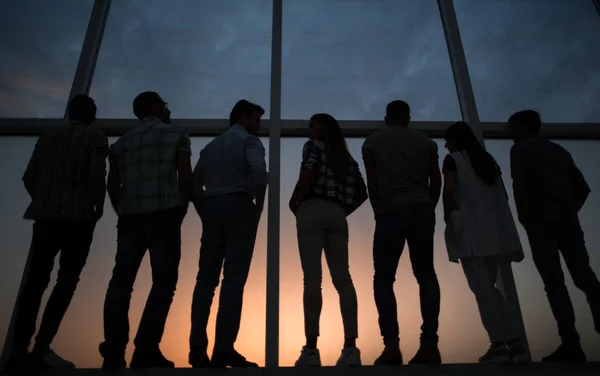 Moderno equipo de negocios de pie cerca de una gran ventana . — Foto de Stock