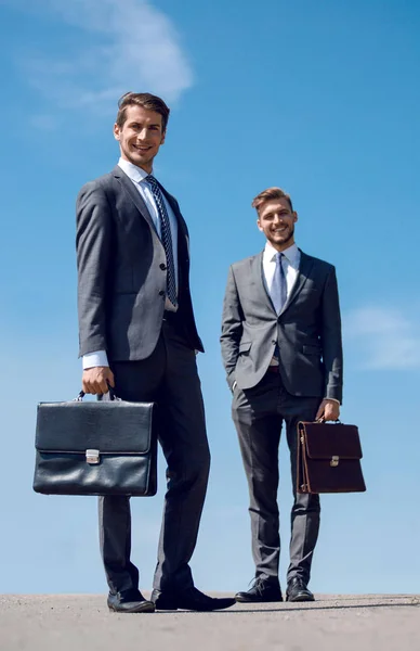两个面带微笑的商务人士与皮革公文包. — 图库照片