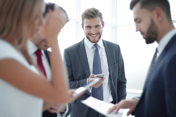 Anställda använder smartphones för att kontrollera finansiella data — Stockfoto