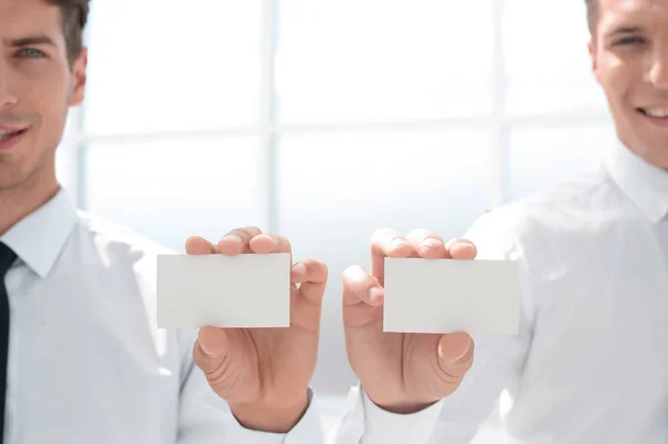 Close up. Two businessmen showing their business cards — стоковое фото