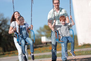 Oyun alanında oynayan iki çocuklu çift