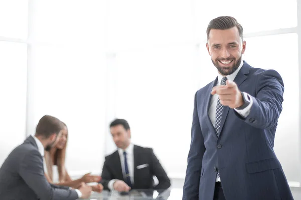 Homem de negócios sorrindo de pé no escritório e apontando para você — Fotografia de Stock
