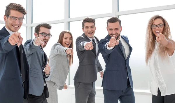 Счастливая деловая команда, стоящая в офисе и указывающая на вас — стоковое фото