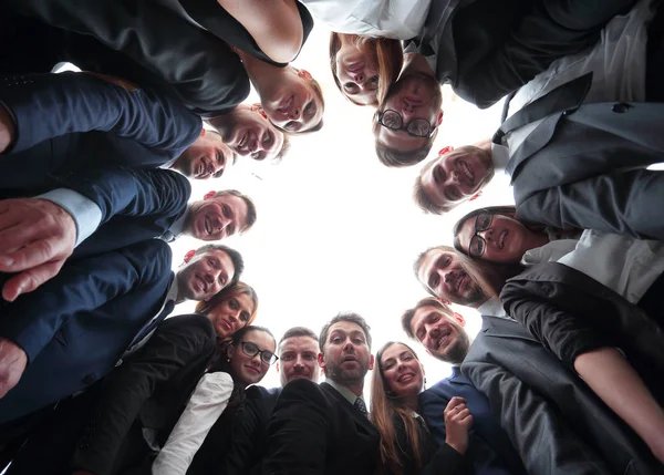 Большая команда бизнесменов формирует круг и смотрит в камеру — стоковое фото