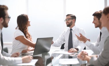 Masa başında oturarak çalışanların gülümseyen