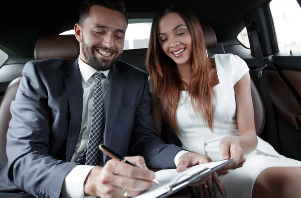 Mooie zakenvrouw werkt met een client in de auto — Stockfoto