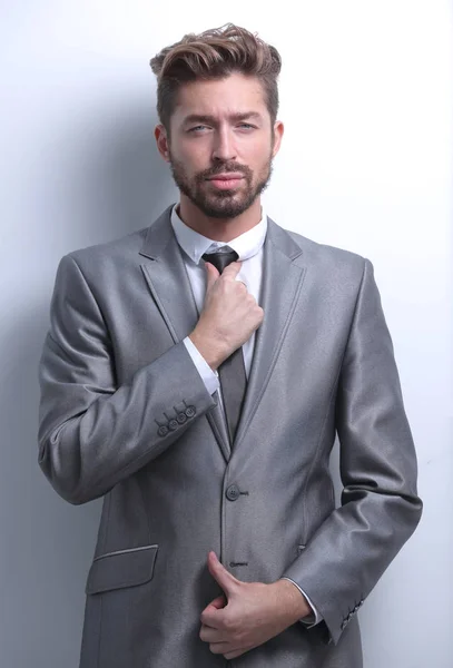 Fashionable businessman preparing his tie isolated over grey — Stock Photo, Image