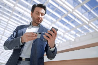 Kapat. İş adamı akıllı telefondan numarayı arıyor.