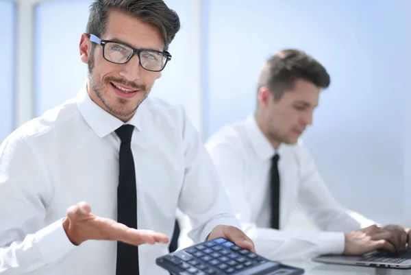 Uomo contando le spese utilizzando calcolatrice con computer portatile sul tavolo. Pinna — Foto Stock