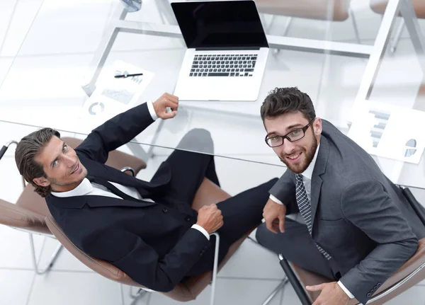 Lachende collega's zitten aan balie — Stockfoto