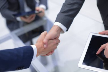 Ofiste iş arkadaşlarıyla tokalaşan adamlar..