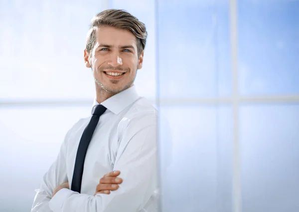 Uomo d'affari sorridente in piedi vicino alla finestra dell'ufficio — Foto Stock