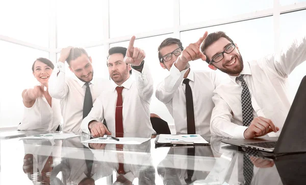 Business-Team sitzt am Schreibtisch und zeigt auf Sie — Stockfoto