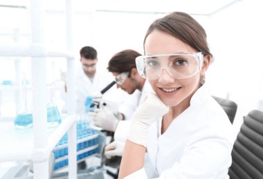 Araştırmacı kontrol test tüpleri, kadın koruyucu gözlük takıyor.