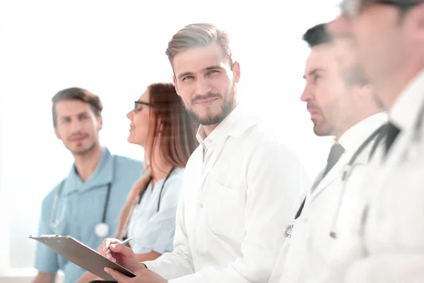 Close up of smiling doctor sitting with his team — Stock Photo, Image