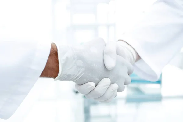 Kézfogás a fehér orvosi kesztyűk — Stock Fotó