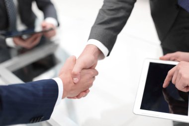 Ofiste iş arkadaşlarıyla tokalaşan adamlar..