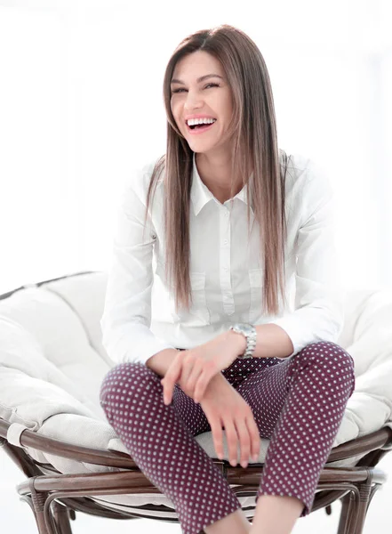 Lachende junge Frau im bequemen Stuhl — Stockfoto
