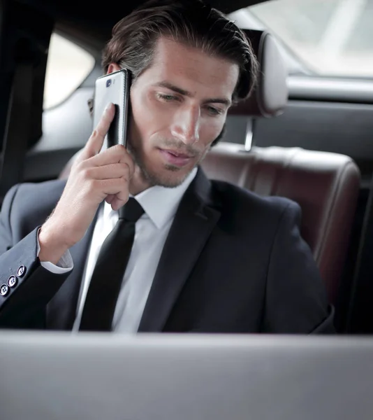 Pohledný podnikatel pomocí mobilního telefonu v autě. — Stock fotografie