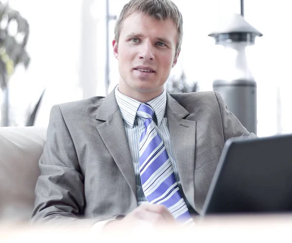 Happy successful businessman sitting on couch at office and working — Stock Photo, Image