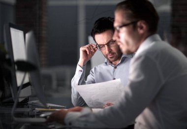 Patron ve gece toplantı kağıtları tartışmaya çalışan