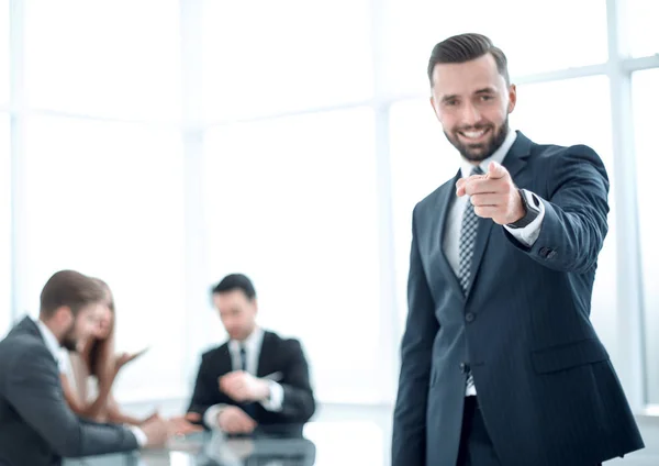 Homme d'affaires souriant debout dans le bureau et vous pointant du doigt — Photo