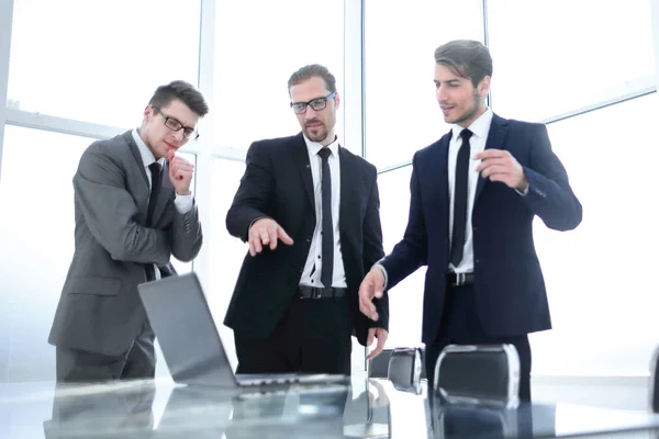 Tre affärsmän som står nära skrivbordet — Stockfoto