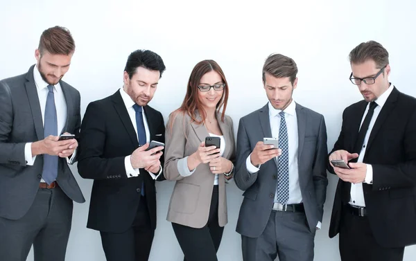 Gruppe von Geschäftsleuten blickt auf die Bildschirme ihrer Smartphones — Stockfoto