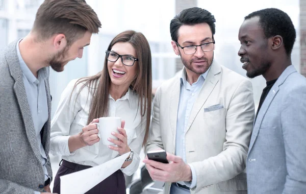 De cerca. equipo de negocios lee SMS en el teléfono inteligente — Foto de Stock