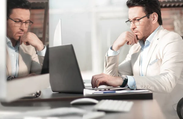 Geschäftsmann denkt im Büro hinter einer Glaswand. — Stockfoto