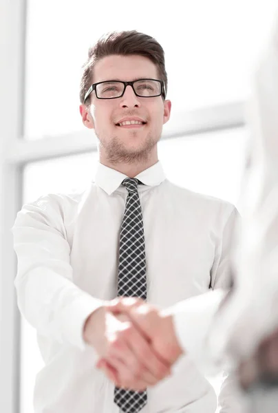 Jovem empresário aperta a mão com um parceiro de negócios — Fotografia de Stock