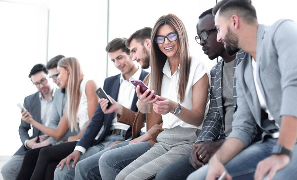 group of young people looking at the screens of their smartphones