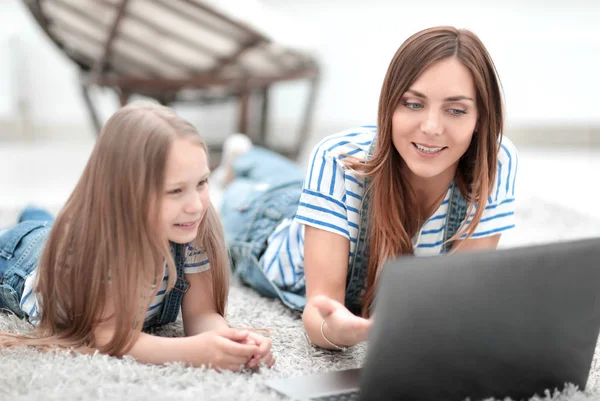 Mãe e pequena filha discutindo algo enquanto olha para o laptop — Fotografia de Stock
