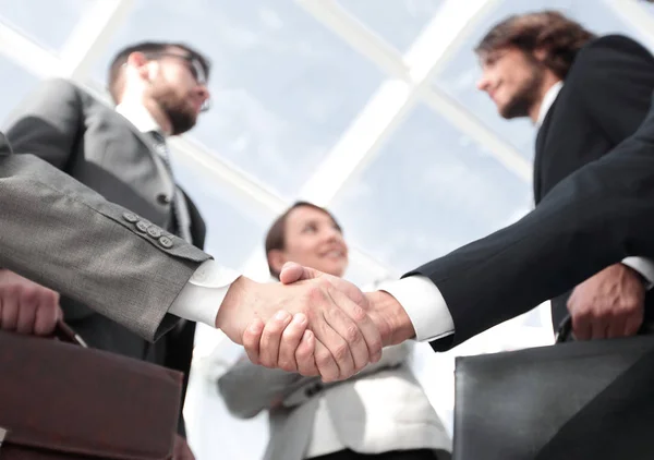 Team looking at a business handshake partner. — Stock Photo, Image