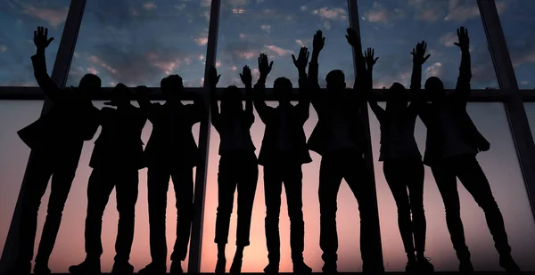 Silhueta de um grupo de empresários levantando a mão — Fotografia de Stock