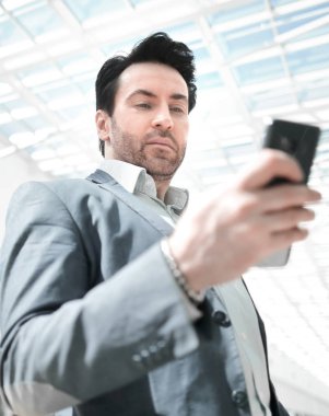 işadamı Havaalanı binasının önünde duran smartphone ile